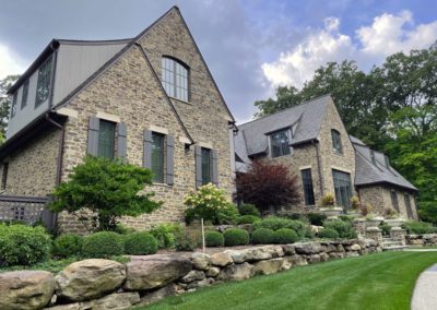 Picture of large brick residential home with stone landscaping